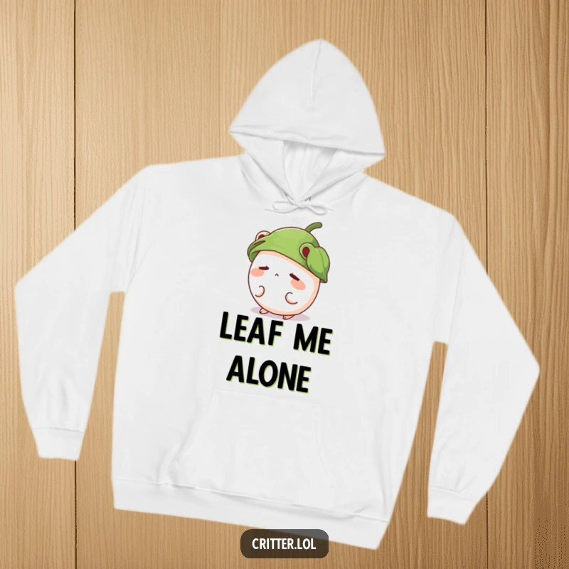 Funny hoodie featuring a shy, round critter wearing a leaf hat and peeking out shyly, perfect for cozy wear.