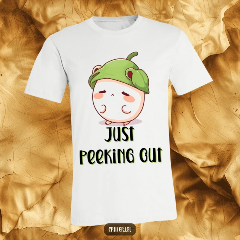 Funny t-shirt graphic of a shy, round critter with a leaf hat peeking out, embodying cute bashfulness.